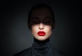 Beautiful model with bright red lips and face half covered in shadow Royalty Free Stock Photo