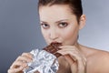 Beautiful model eating chocolate, in the studio Royalty Free Stock Photo