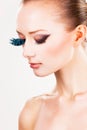 Model with fake turquoise eyelashes colourful eyeshadow eyes gazed down Royalty Free Stock Photo
