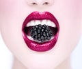 Beautiful model girl eating blackberry, closeup. Beauty young fashion woman lips with fresh organic black berry