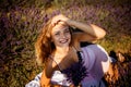 Beautiful model holding a bouquet of fresh lavenders relaxing in the spring or summer lavender field under the rays of the sun. Royalty Free Stock Photo