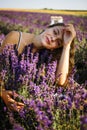 Beautiful model holding a bouquet of fresh lavenders relaxing in the spring or summer lavender field under the rays of the sun. Royalty Free Stock Photo