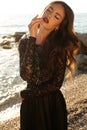 Beautiful model in lace black dress posing on beach Royalty Free Stock Photo