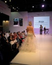Beautiful model posing catwalk on stage showing wedding and bridal dresses
