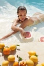 Beautiful Model`s Portrait In Pool With Citrus. Woman In Bikini Enjoying Fresh Exotic Fruit At SPA. Royalty Free Stock Photo