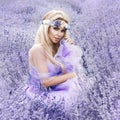 Beautiful model walking in spring or summer lavender field in sunrise . Blond long haired girl in lavender field Royalty Free Stock Photo