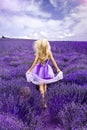 Beautiful model walking in spring or summer lavender field in sunrise . Blond long haired girl in lavender field Royalty Free Stock Photo