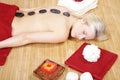 Beautiful model at wellness massage with hot stone