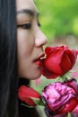 Beautiful model woman kissing red rose flower Royalty Free Stock Photo