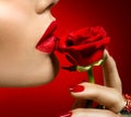 Beautiful model woman kissing red rose flower