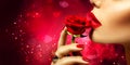 Beautiful model woman kissing red rose flower Royalty Free Stock Photo