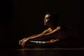 Beautiful modern ballet dancer with perfect body sits on the floor in the studio hall. Royalty Free Stock Photo