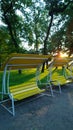 Beautiful modern bench-swing in a public Park of the city at sunset. Vertical view Royalty Free Stock Photo