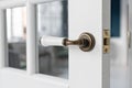 Beautiful modern door knob. Open, wooden front door from the interior of an upscale home with windows. Royalty Free Stock Photo