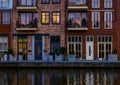 Beautiful modern dutch city architecture at night, terraced houses at the canal with balconies, Alphen aan den Rijn, The