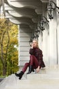 A beautiful, modern, fashionable blonde girl with a red lipstick posing outdoors . red leather leggings, turtleneck and Royalty Free Stock Photo