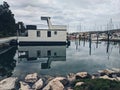 Beautiful modern floating house in the Adriatic sea, moored to the shore. Beach with a lot of yachts. Summer travel concept. Royalty Free Stock Photo