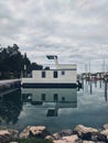 Beautiful modern floating house in the Adriatic sea, moored to the shore. Beach with a lot of yachts. Summer travel concept. Royalty Free Stock Photo