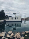 Beautiful modern floating house in the Adriatic sea, moored to the shore. Beach with a lot of yachts. Summer travel concept. Royalty Free Stock Photo