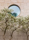 Beautiful modern house with round window and spring blossom tree. Round shape of glass window on a brick wall building Royalty Free Stock Photo