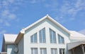 Beautiful modern house with white walls, white roof tiles and large panoramic home attic windows Royalty Free Stock Photo