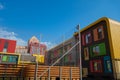 Beautiful modern houses painted in bright colors.Beautiful blue sky and clouds.Auto-watering system and rainbow in jets of water Royalty Free Stock Photo