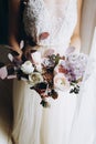 Beautiful modern pink and white bouquet in brides`s hands. Close up of wedding bouquet with different flowers Royalty Free Stock Photo