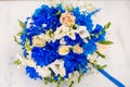 Beautiful modern wedding bouquet of blue chrysanthemum, freesia, roses and peony. on white wooden background. With rings Royalty Free Stock Photo