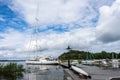 Beautiful modern white sailing yacht at the pier slowly leaves the coast and sails. Gulf of the Baltic Sea in summer day. Marina Royalty Free Stock Photo