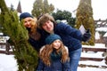 Beautiful mom, dad and daughter doing selfie with freshly cut christmas tree with smartphone near home. Young family Royalty Free Stock Photo