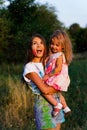 Beautiful mom and daughter play with Hol colors. multi-colored paint on clothes and face