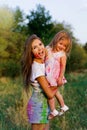 Beautiful mom and daughter play with Hol colors. multi-colored paint on clothes and face Royalty Free Stock Photo