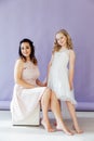 Beautiful mom and daughter in white dresses in close family