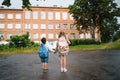 Beautiful mom and her cute little daughter are holding shopping bags, looking at camera and smiling while standing outdoors. Royalty Free Stock Photo