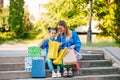 Beautiful mom and her cute little daughter are holding shopping bags, looking at camera and smiling while standing outdoors. Royalty Free Stock Photo