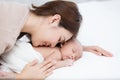 Mother with infant baby on white bed Royalty Free Stock Photo