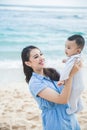 Beautiful mom playng with her kids at the beach