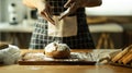 Beautiful moment of baker wearing apron sifting flour on dough, making bread in kitchen Royalty Free Stock Photo