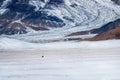 Beautiful Mongolian winter landscape snow mountain with a small figure of a rider on a black horse galloping through a wide snow- Royalty Free Stock Photo