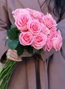 Beautiful mono bouquet of pink roses. Woman in brown coat holding bouquet of roses Royalty Free Stock Photo