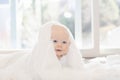 Beautiful 6 Month Baby Boy Dressed in White & Lying on Fluffy White Blanket Looking at Camera. Smiling & Happy Royalty Free Stock Photo