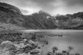 Beautiful moody Winter landscape image of Llyn Idwal and snowcapped Glyders Mountain Range in Snowdonia in black and white