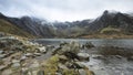 Beautiful moody Winter landscape image of Llyn Idwal and snowcapped Glyders Mountain Range in Snowdonia