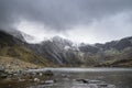 Beautiful moody Winter landscape image of Llyn Idwal and snowcapped Glyders Mountain Range in Snowdonia