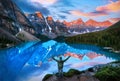 Beautiful Moraine Lake reflections with hiker in awe of golden sunrise over the Valley of the Ten Peaks in the Canadian Rockies Royalty Free Stock Photo