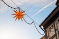 Beautiful Moravian star or Herrnhuter Stern street glowing decoration hanged on wall german city street at christmas Royalty Free Stock Photo