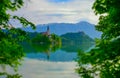 Beautiful morning at Lake Bled and Julian Alps in the background, with natural frame. The lake island and charming church are
