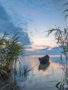 Beautiful morning landscape with a boat on the lake at the sunrise through the reed Royalty Free Stock Photo