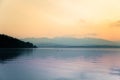 A beautiful morning landscape with ducks swimming in the mountain lake with mountains in distance. Sunset scenery in light colors. Royalty Free Stock Photo