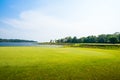 Green grass field with lake in public park Royalty Free Stock Photo